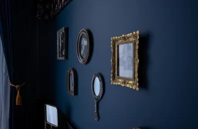 a blue wall with pictures and a mirror on it at Craves in Brussels