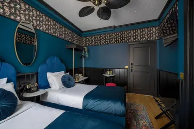 a blue room with two beds and a mirror at Craves in Brussels