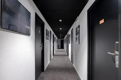 a hallway with black doors and a long corridor at Aris Grand Place Hotel in Brussels