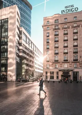 a person walking in front of a building at Hotel Indigo Brussels - City by IHG in Brussels