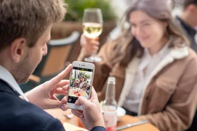 a man taking a picture of a woman with a cell phone at Hotel Indigo Brussels - City by IHG in Brussels