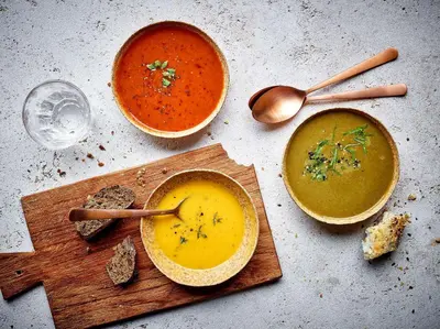 a table with two bowls of soup and a glass of wine at NH Brussels EU Berlaymont in Brussels