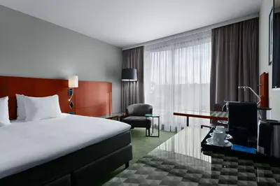 a hotel room with a bed and a desk at NH Brussels EU Berlaymont in Brussels
