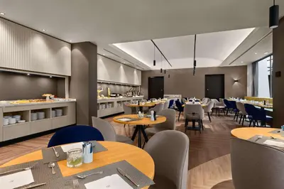 a restaurant with tables and chairs and a cafeteria at NH Brussels EU Berlaymont in Brussels