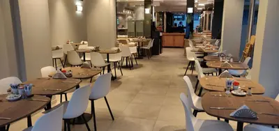 a restaurant with wooden tables and white chairs at Best Western Hotel Royal Centre in Brussels