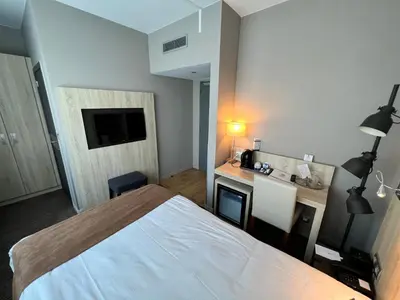 a bedroom with a bed and a desk with a television at Best Western Hotel Royal Centre in Brussels