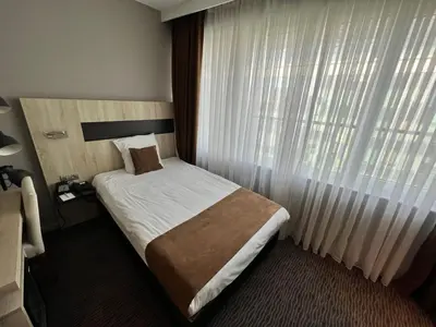 a hotel room with a bed and a large window at Best Western Hotel Royal Centre in Brussels