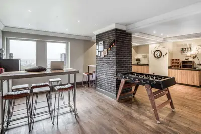 a living room with a table and a brick fireplace at pentahotel Brussels City Centre in Brussels