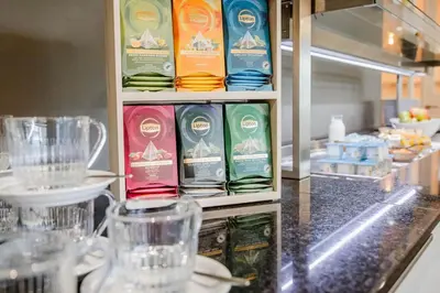 a counter in a restaurant with a shelf of food at Hotel Corsendonk Viane in Turnhout