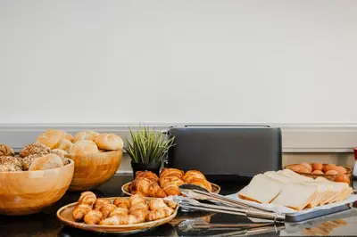 a table topped with bread and pastries and baskets of food at Hotel Corsendonk Viane in Turnhout