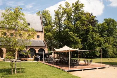 a pavilion with tables and chairs in front of a building at Priorij Corsendonk in Oud-Turnhout