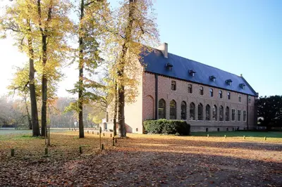 a large building with trees in front of it at Priorij Corsendonk in Oud-Turnhout