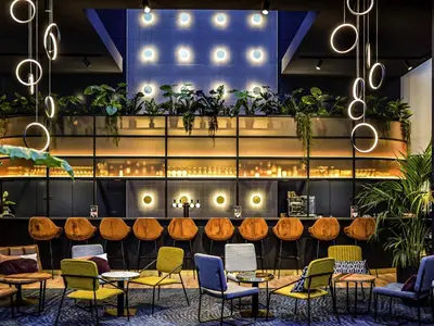 a restaurant with wooden tables and chairs and plants at Mercure Antwerp City South in Antwerp