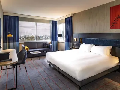 a bedroom with a large bed and a living room at Mercure Antwerp City South in Antwerp