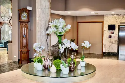 a glass table with a vase filled with white flowers at Bedford Hotel Brussels in Brussels