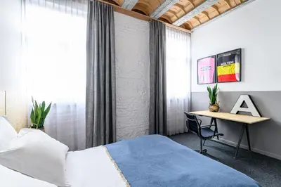 a bedroom with a bed and a desk at Hotel La Grande Cloche in Brussels