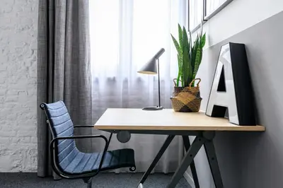 a desk with a computer and a chair next to a window at Hotel La Grande Cloche in Brussels