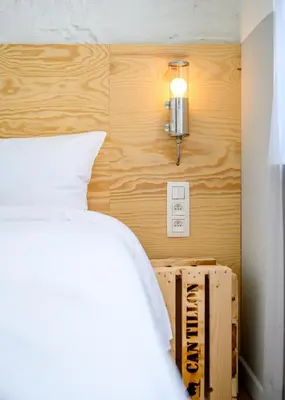 a bedroom with a bed and a light on a wall at Hotel La Grande Cloche in Brussels