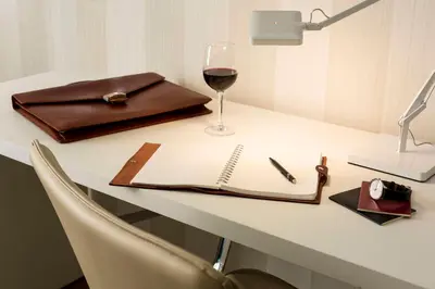 a table with a book and a glass of wine at NH Collection Brussels Centre in Brussels
