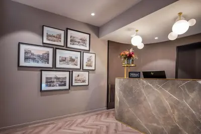 a lobby with a reception desk and framed pictures on the wall at DoubleTree By Hilton Brussels City in Brussels