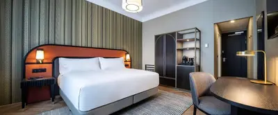 a bedroom with a bed and a desk and a table and a chair at DoubleTree By Hilton Brussels City in Brussels