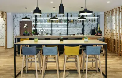 a bar with three tables and four chairs at Hilton Garden Inn Brussels City Centre in Brussels
