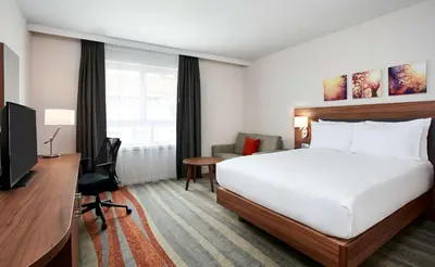 a hotel room with a bed and a desk and a television at Hilton Garden Inn Brussels City Centre in Brussels