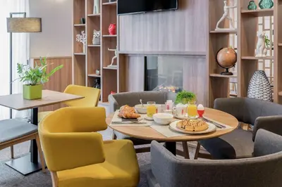 a dining room with a table and chairs and a fireplace at Hilton Garden Inn Brussels City Centre in Brussels