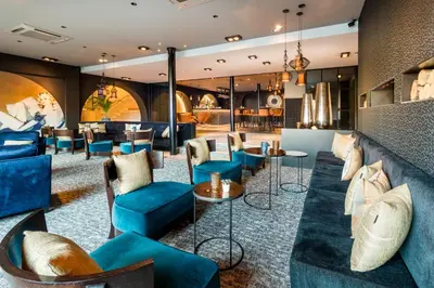 a lobby of a hotel with blue chairs and tables at Martin's Château Du Lac in Genval
