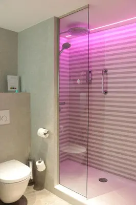 a bathroom with a shower with purple lighting at Martin's Château Du Lac in Genval