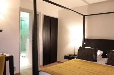 a bedroom with a bed with a black frame and a mirror at Martin's Château Du Lac in Genval