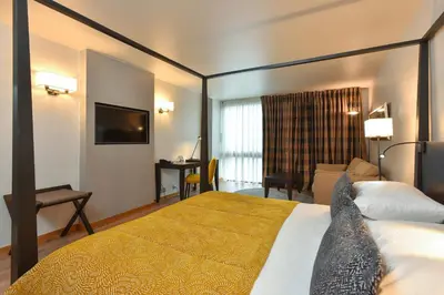 a hotel room with a bed and a living room at Martin's Château Du Lac in Genval