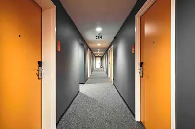 a hallway with orange and gray walls and a hallway with doors at easyHotel Brussels City Centre in Brussels