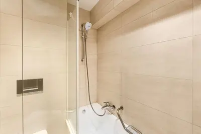 a shower with a glass door in a bathroom at NH Brussels Stéphanie in Brussels