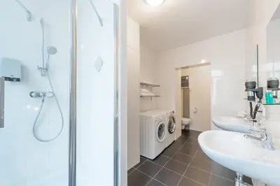 a bathroom with two sinks and a washing machine at Hotel Docklands Antwerpen in Antwerp