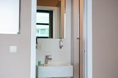a bathroom with a sink and a mirror at Hotel Docklands Antwerpen in Antwerp