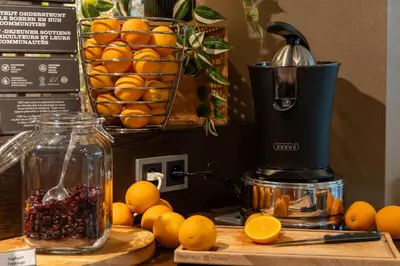 a juicer sitting on top of a table with oranges at Hotel Docklands Antwerpen in Antwerp