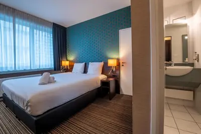 a hotel room with a bed and a bathroom at Hotel Docklands Antwerpen in Antwerp