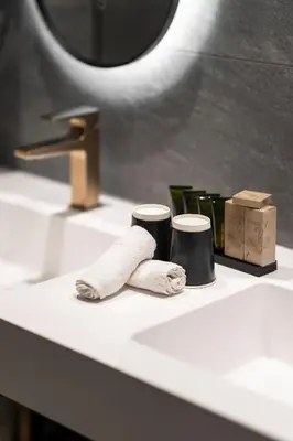 a towel and two cups on a bathroom sink at Van der Valk Waterloo in Waterloo