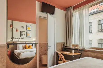 a hotel room with a bed and a mirror at The Usual Brussels in Brussels