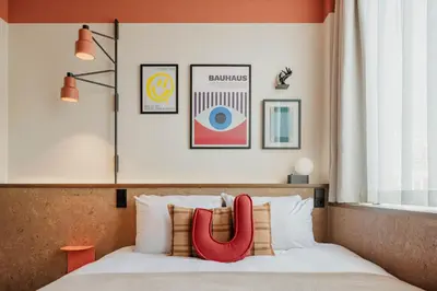 a bedroom with a bed with three pictures on the wall at The Usual Brussels in Brussels