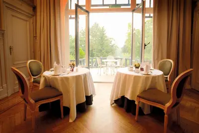 a room with two tables and chairs and a large window at Martin's Manoir in Genval