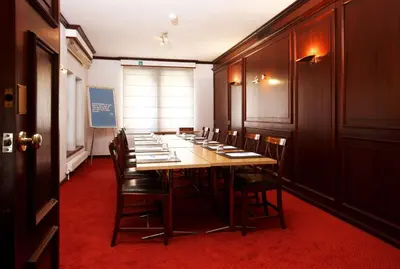 a conference room with a long table and chairs at NH Mechelen in Mechelen