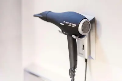 a hair dryer is attached to a wall at NH Mechelen in Mechelen