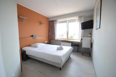 a hotel room with a bed and a desk at Sleep & Go Brussels Expo Hotel in Brussels