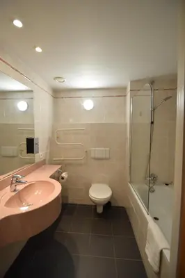 a bathroom with a sink and a toilet and a shower at Sleep & Go Brussels Expo Hotel in Brussels