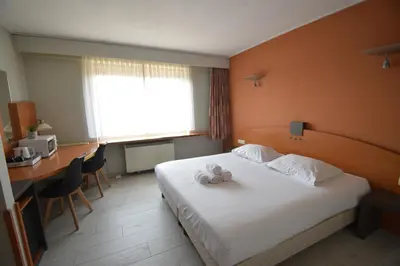 a hotel room with a bed with two stuffed animals on it at Sleep & Go Brussels Expo Hotel in Brussels