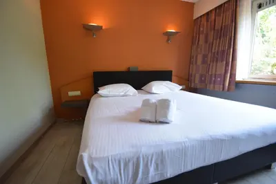 a bedroom with a bed with two white towels on it at Sleep & Go Brussels Expo Hotel in Brussels
