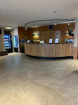 a lobby with a bar in the middle of a building at Sleep & Go Brussels Expo Hotel in Brussels