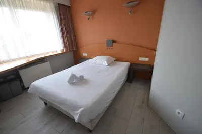 a bedroom with a bed with a cross on it at Sleep & Go Brussels Expo Hotel in Brussels